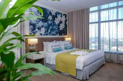 a hotel room with a bed and a large window at Citadines Millennium Ortigas Manila in Manila