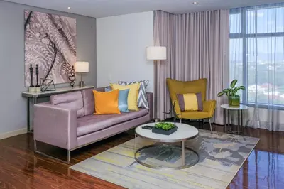 a living room with a couch and two chairs at Citadines Millennium Ortigas Manila in Manila