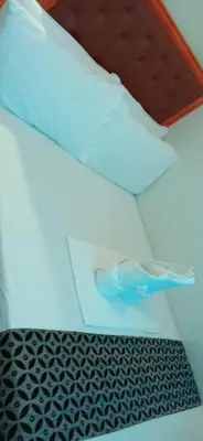 a white envelope with a pair of shoes on a floor at Chin's Place Sea Residences MOA in Manila