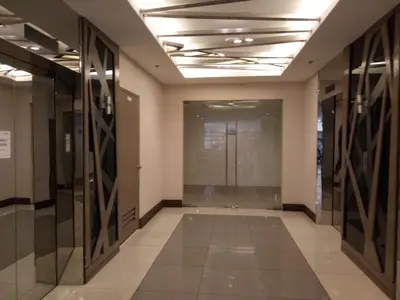 an empty hallway of an office building with glass doors at Chin's Place Sea Residences MOA in Manila
