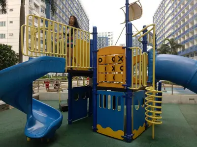 a woman is standing in a playground at Chin's Place Sea Residences MOA in Manila
