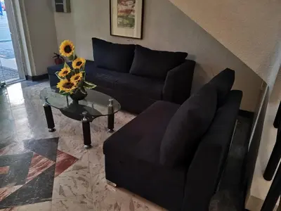 a living room with a black couch and a table at Jupiter Suites in Manila