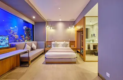 a room with a bed and a fish tank at Hotel H2O in Manila