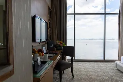 a hotel room with a desk with a view of the water at Hotel H2O in Manila