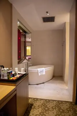 a bathroom with a tub and a sink at Hotel H2O in Manila