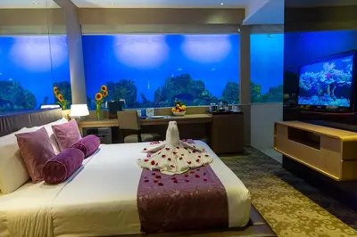 a hotel room with a large bed and a television at Hotel H2O in Manila
