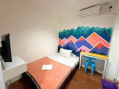 a small room with a bed and a painting on the wall at Dormitelsph España in Manila