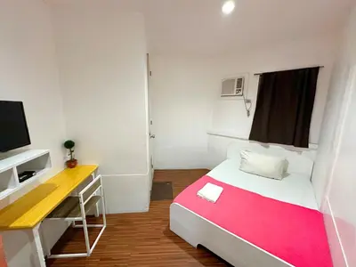 a small room with a bed and a desk at Dormitelsph España in Manila