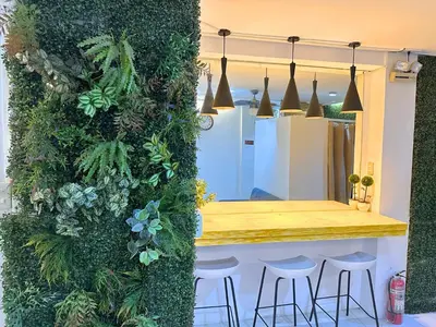 a green wall with stools at a bar at Dormitelsph España in Manila