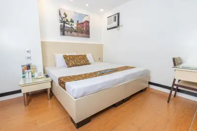 a small bedroom with a bed and a desk at Eurotel Pedro Gil in Manila