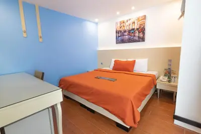a bedroom with a bed with an orange blanket at Eurotel Pedro Gil in Manila
