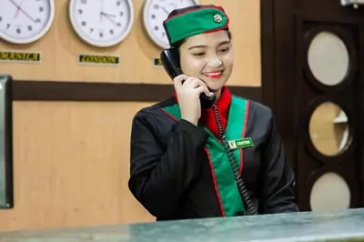 a woman in uniform talking on a cell phone at Eurotel Pedro Gil in Manila