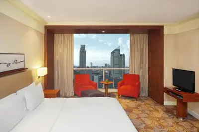 a hotel room with a bed and a large window at New Coast Hotel Manila in Manila
