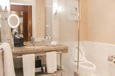 a bathroom with a toilet and a sink at New Coast Hotel Manila in Manila