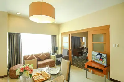 a living room with a couch and a table in a room at Makati Palace Hotel in Manila