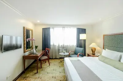 a hotel room with a bed and a desk at Makati Palace Hotel in Manila