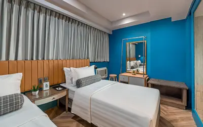 a hotel room with two beds and a mirror at Makati Palace Hotel in Manila