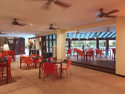 a restaurant with red chairs and tables and windows at The Heritage Hotel Manila in Manila