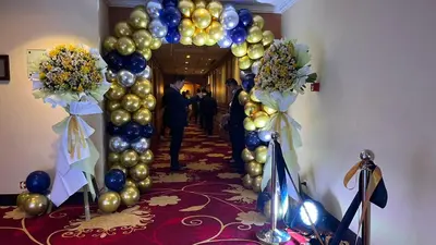 a hallway with a arch with balloons and a man at The Heritage Hotel Manila in Manila