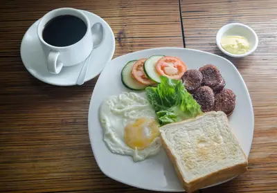 a plate of breakfast food with a cup of coffee at Spaces Hotel Makati in Manila