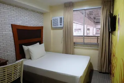 a bedroom with a white bed and a window at Spaces Hotel Makati in Manila