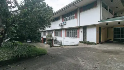 an empty parking lot next to a white building at RedDoorz at Broadway Court Apartelle Quezon City in Manila