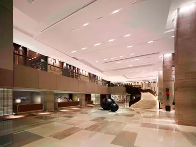 a lobby with a spiral staircase in a building at New World Makati Hotel, Manila in Manila