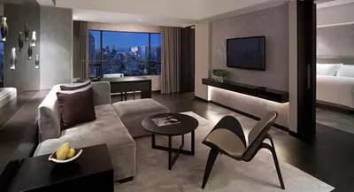 a living room with a couch and a bed at New World Makati Hotel, Manila in Manila