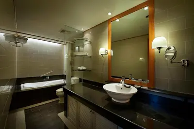 a bathroom with a sink and a mirror at Berjaya Makati Hotel in Manila