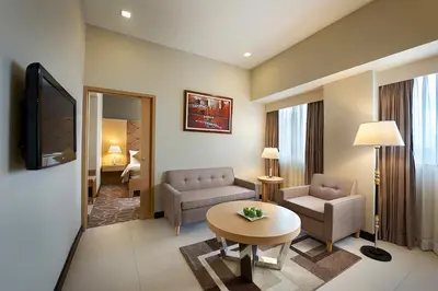 a living room with a couch and a table at Berjaya Makati Hotel in Manila