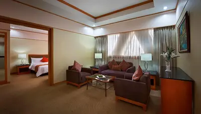 a hotel room with a couch and a bed at Berjaya Makati Hotel in Manila