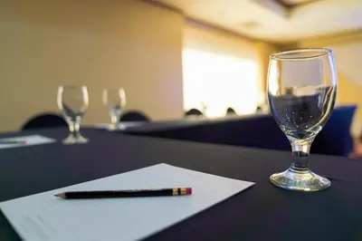a glass of wine and a pen on a table at Berjaya Makati Hotel in Manila