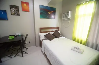 a bedroom with a bed and a desk and a desk at Yong's Place at Vista Residences Taft in Manila