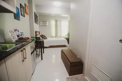 a room with a kitchen and a bedroom with a bed at Yong's Place at Vista Residences Taft in Manila