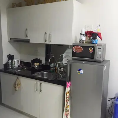 a kitchen with a microwave on top of a refrigerator at Luxury Condo-Princeton Residence-New Manila Quezon City-Fast Wi-fi150mbps in Manila