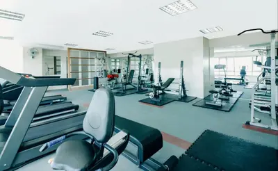 a gym with several treadmills and cardio machines at Greenhills Elan Hotel Modern - Newly Renovated in Manila
