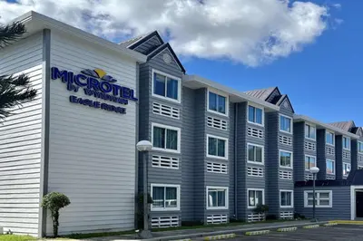 a large white building with a sign on it at Microtel by Wyndham Eagle Ridge in General Trias