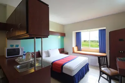 a hotel room with a bed and a sink at Microtel by Wyndham Eagle Ridge in General Trias
