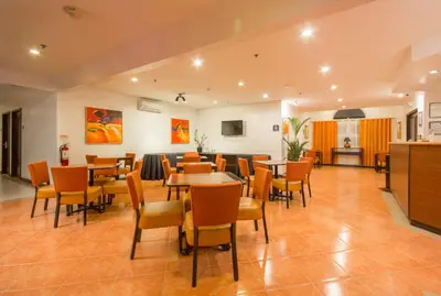 a restaurant with tables and chairs in a room at Microtel by Wyndham Eagle Ridge in General Trias