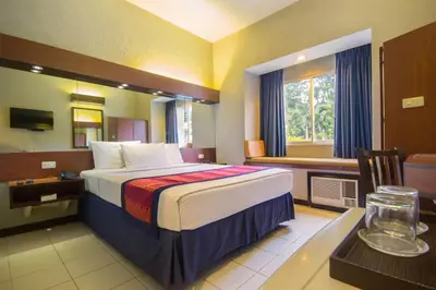 a hotel room with a bed and a desk with a desk at Microtel by Wyndham Eagle Ridge in General Trias