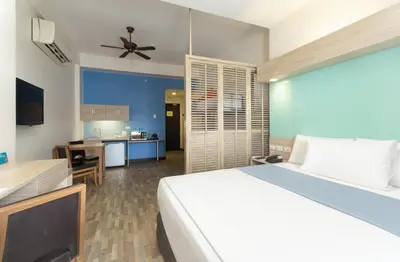 a bedroom with a large bed and a kitchen at Microtel by Wyndham Mall of Asia in Manila