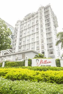 a large white building with a sign in front of it at Microtel by Wyndham Mall of Asia in Manila