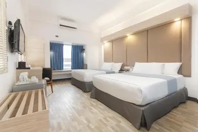 a hotel room with a large bed and a couch at Microtel by Wyndham Mall of Asia in Manila