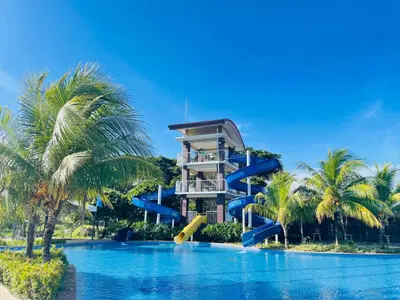 a resort with a slide in the middle of a pool at Aquamira Hotel & Resort in Tanza