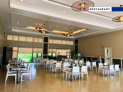 a restaurant with white tables and white chairs at Aquamira Hotel & Resort in Tanza