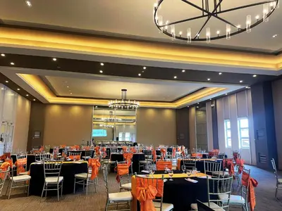 a banquet hall with tables and chairs and a chandelier at Aquamira Hotel & Resort in Tanza