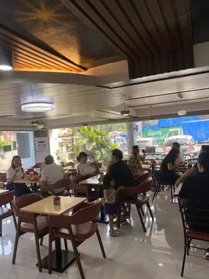 a group of people sitting at tables in a restaurant at Comfy Inn Manila-Kalaw in Manila