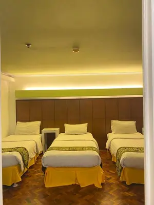 a hotel room with three beds in a room at Comfy Inn Manila-Kalaw in Manila