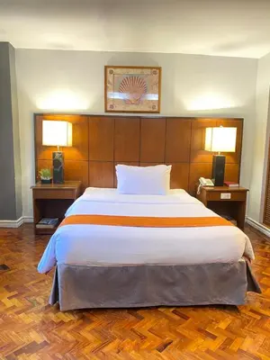 a large bed in a hotel room with two lamps at Comfy Inn Manila-Kalaw in Manila