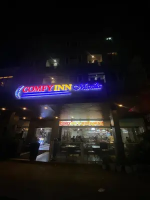 a restaurant with a neon sign on the front of it at Comfy Inn Manila-Kalaw in Manila